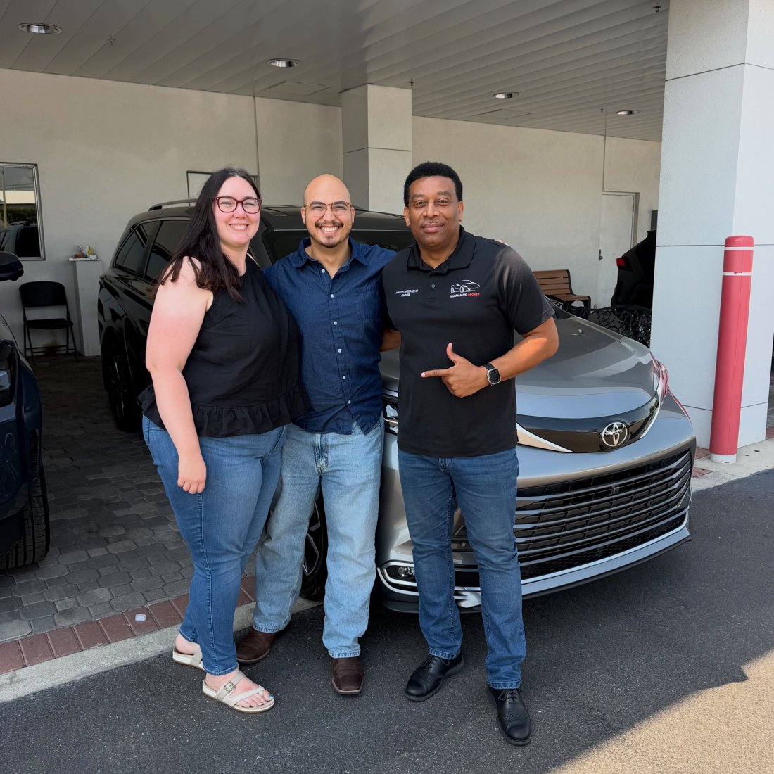 Martindale with customers beside a silver Toyota minivan